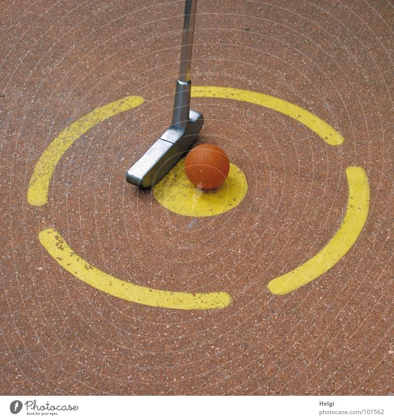 Minigolfschläger und Minigolfball am Abschlagspunkt auf einer Minigolfanlage schlagen Golfball Beton Betonboden Spielen Sportveranstaltung Erfolg Verlierer