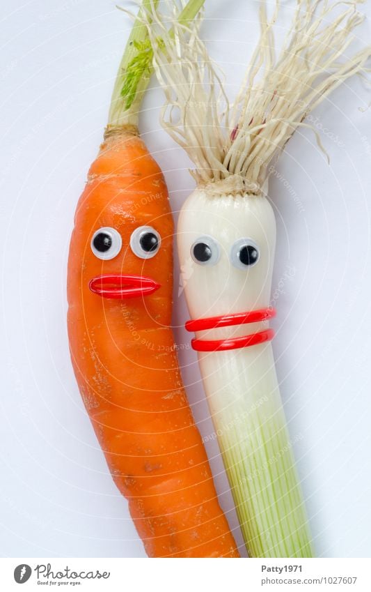 Gemüse mit aufgeklebten Kulleraugen stellt ein ein verliebtes Paar dar. Möhre Zwiebel Schalotten Gesicht Auge Mund grün orange weiß Fröhlichkeit Akzeptanz