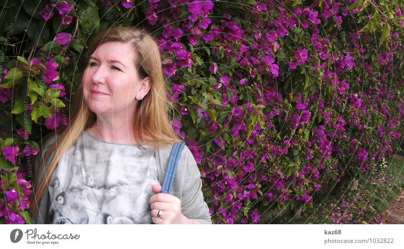 Im Park feminin Frau Erwachsene Pflanze Blume Garten beobachten Blühend Duft gehen Lächeln blond Freundlichkeit Fröhlichkeit violett Zufriedenheit