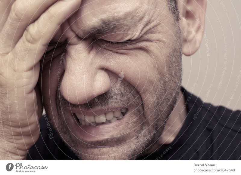 Koppschmerzn Mensch maskulin Mann Erwachsene Kopf Gesicht Finger 1 45-60 Jahre braun Kopfschmerzen festhalten Stirnfalte Hautfalten Dreitagebart Zähne zeigen