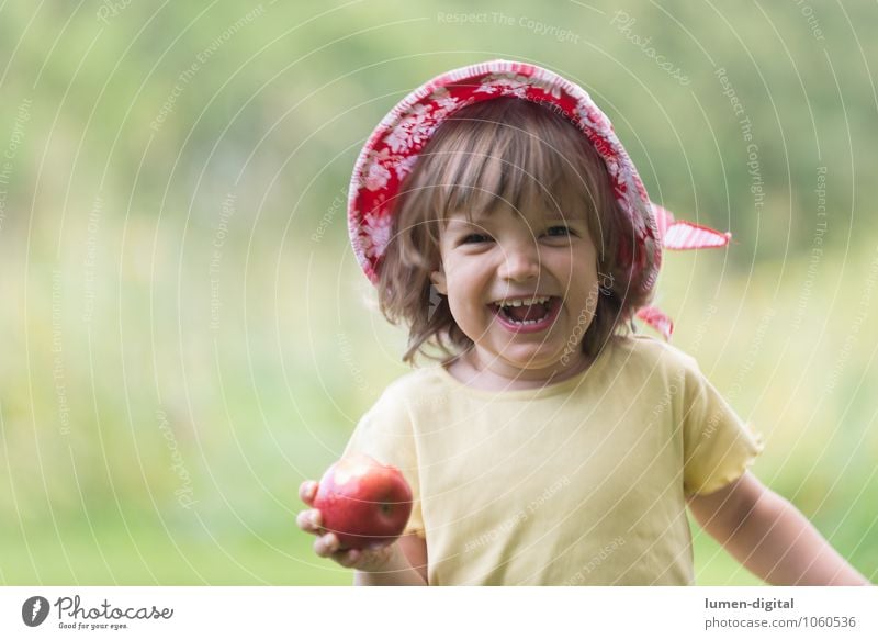 Kind freut sich mit Apfel Frucht Ernährung Freude Gesicht Sommer Mensch Kleinkind Mädchen 1-3 Jahre 3-8 Jahre Kindheit Hut Essen lachen Fröhlichkeit frisch
