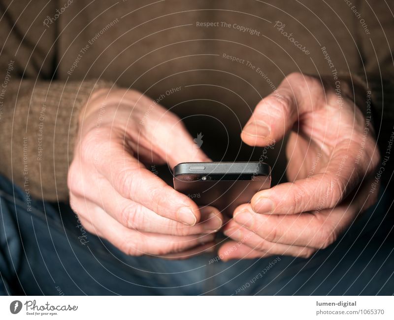 Hände mit Smartphone Handy PDA Finger Kommunizieren sitzen Telefongespräch Chatten clipping device electronic hands holding jeans man sitting sweater tap touch