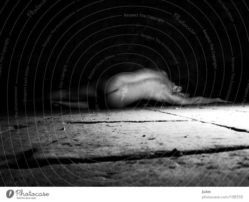Im Gewölbekeller nackt Mann maskulin Kerl Akt Bodenbelag Rücken Perspektive Typ Steinboden Vor dunklem Hintergrund Gesäß Rückansicht liegen Textfreiraum oben