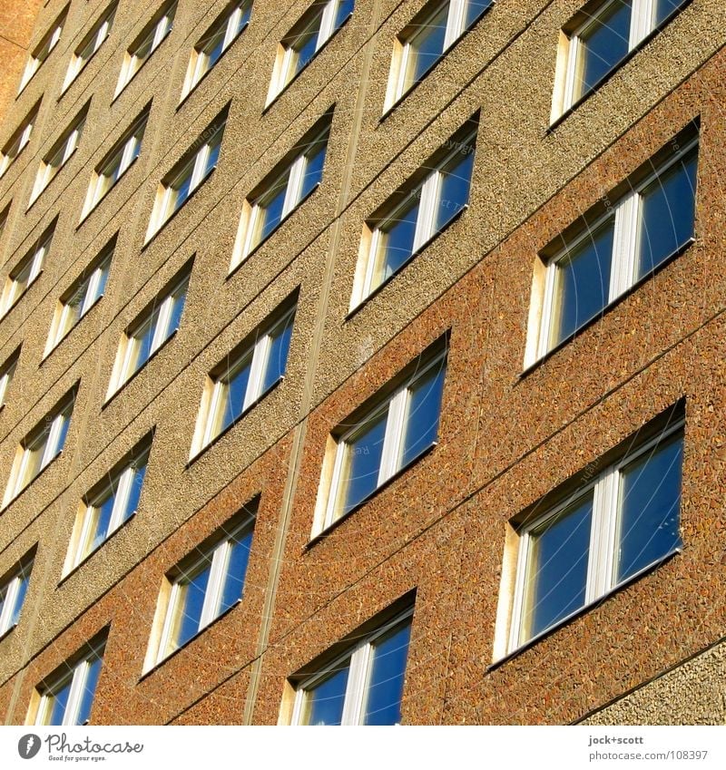 unscheinbare Fassade Architektur Plattenbau Fenster eckig hässlich trist braun Norm Geometrie aufeinander Anordnung DDR diagonal Rechteck Funktionalismus