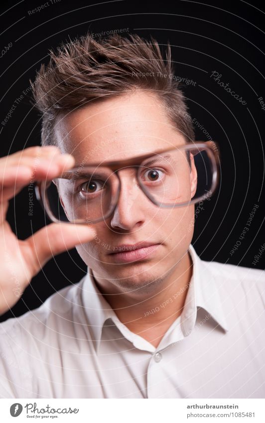 Junger Mann hat Brille in der Hand und sieht schockiert durch Gläser kaufen Freude Wissenschaften lernen Student Mensch maskulin Jugendliche 1 18-30 Jahre