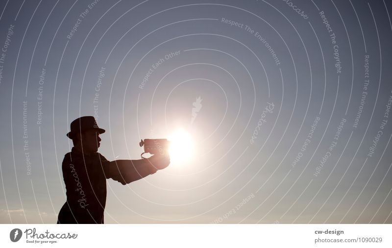 Jugendlicher mit Super 8 Kamera Silhouette Sonne Kanone Waffe Mann Mann mit Hut Mensch Farbfoto Videokamera Filmindustrie Freizeit & Hobby Außenaufnahme