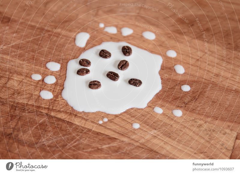Milchkaffee, die Erste Lebensmittel Heißgetränk Kaffee Latte Macchiato skurril Kaffeebohnen Tropfen Holzbrett Holztisch lustig Humor außergewöhnlich verteilt