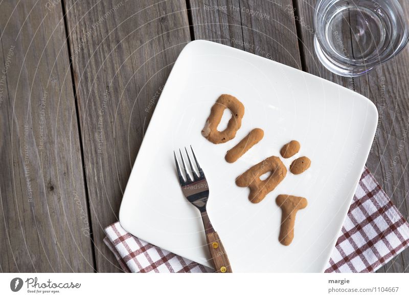 Die Buchstaben DIÄT auf einem Teller mit Serviette, Gabel und einem Wasserglas auf einem rustikalen Holztisch Ernährung Frühstück Mittagessen Abendessen