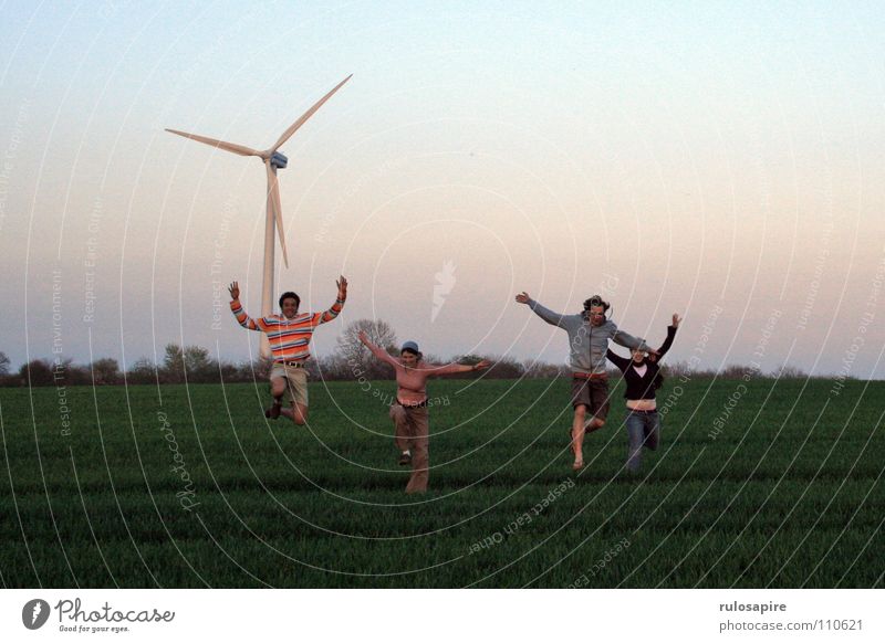 Spring! grün Feld springen Mensch bewegungslos drehen weiß groß dünn technisch Wiese saftig Abendsonne rot Engagement Freude Wind Windkraftanlage