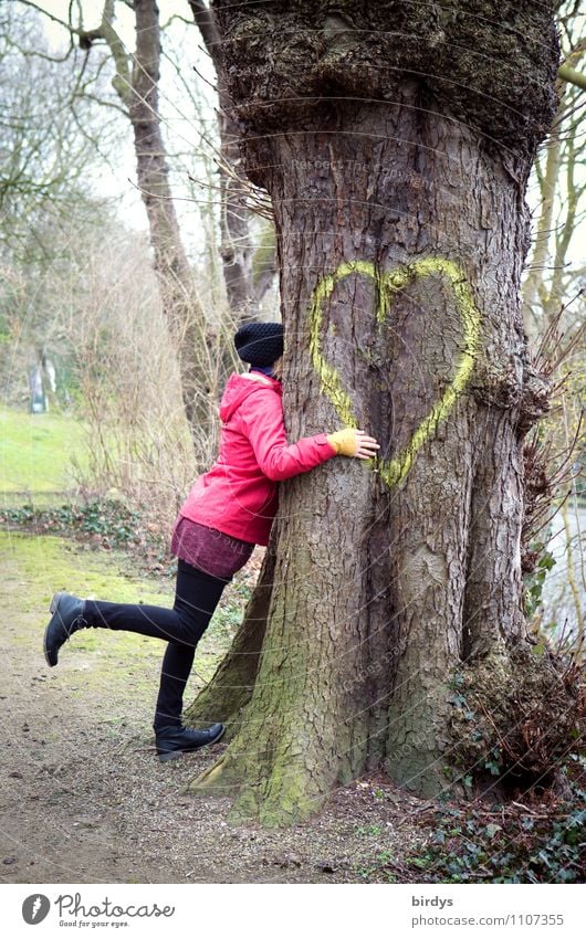 Glückliche Frau umarmt einen großen Baum mit einem Herzen Junge Frau Jugendliche Erwachsene 1 Mensch 30-45 Jahre Park Zeichen berühren Liebe Umarmen authentisch