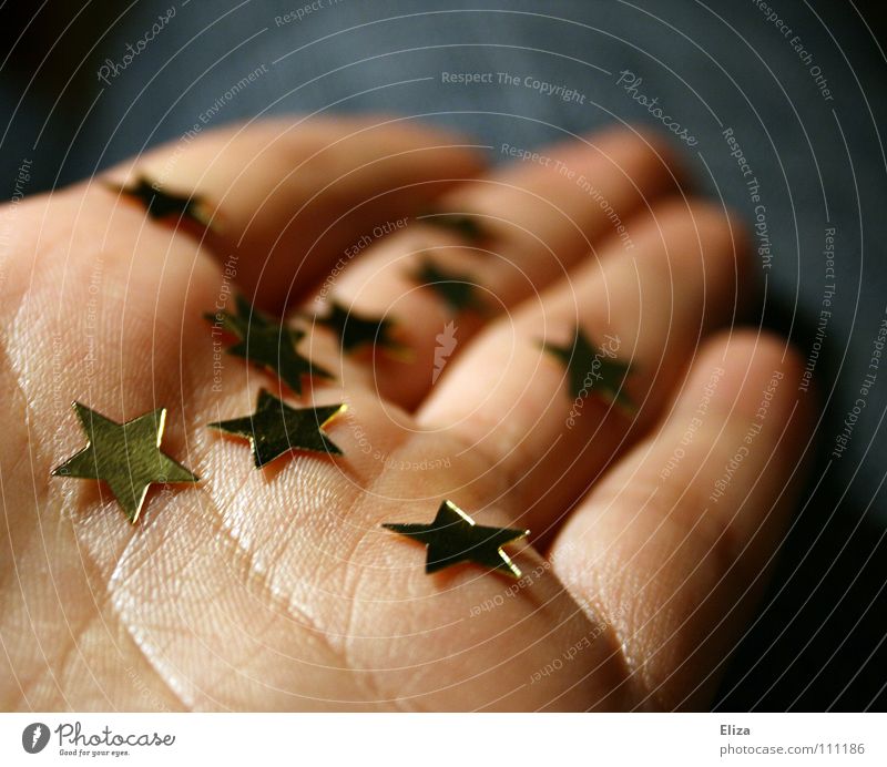 Eine Person hält goldene Sterne in der Hand geben schenken Weihnachten Europa Geschenk