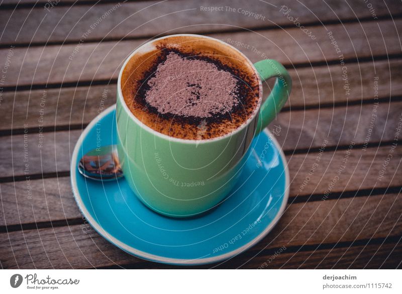 Eine Tasse Cappuccino mit Herz. Tasse steht auf einem Holztisch mit einem Löffel und Unterteller. Schokolade Kaffeetrinken Heißgetränk Freude Gesundheit