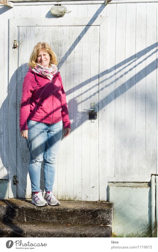 freundlich verbunden Mensch feminin Frau Erwachsene 1 45-60 Jahre Haus Bekleidung Jeanshose Turnschuh blond stehen Fröhlichkeit hell Glück Optimismus