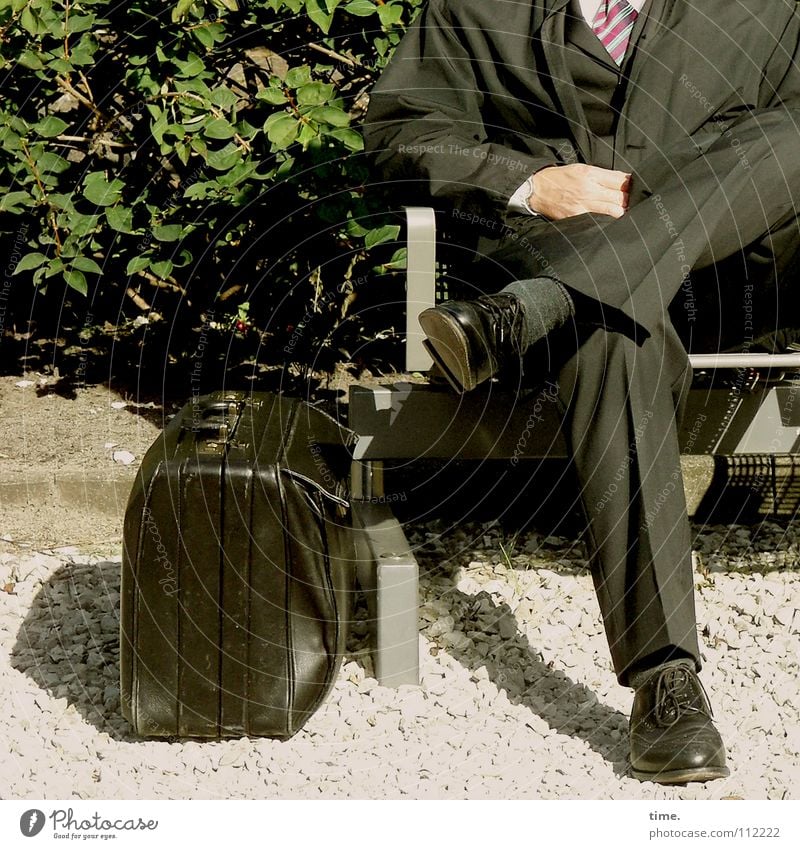 Der Anzug sitzt Farbfoto Gedeckte Farben Außenaufnahme Business maskulin Mann Erwachsene Beine Sträucher Bahnhof Verkehrswege Krawatte Tasche Schuhe sitzen