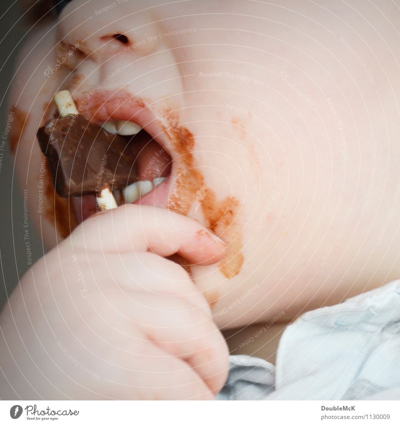 Kleinkind isst Schokolade am Stiel und hat total beschmierten Mund Süßwaren Essen Haut Gesicht Mensch Kopf Zähne Hand 1 1-3 Jahre Besenstiel festhalten dreckig