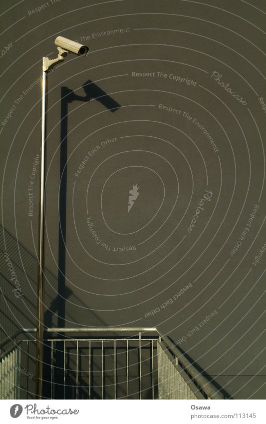 Gucksdu Überwachungskamera Wand grau dunkel überwachen Privatsphäre Überwachungsstaat Angst Panik Fotokamera Strommast Schatten Geländer Stasi 2.0