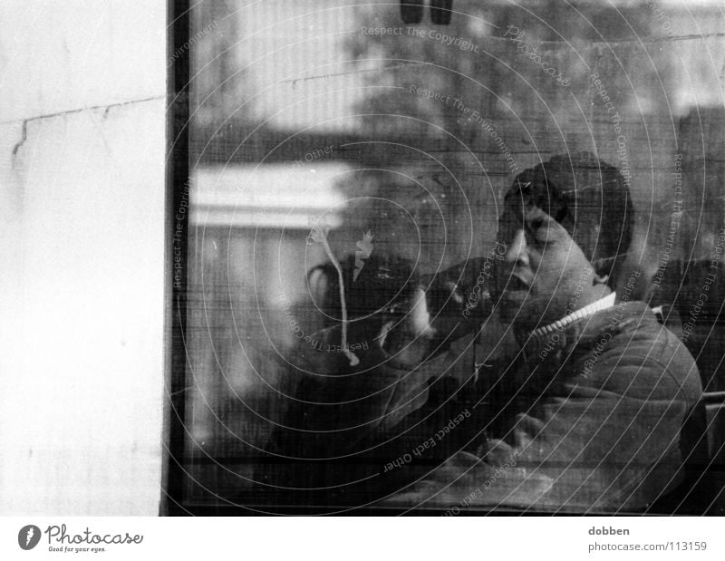 das zweite Gesicht... Mann Handy Telefon Mütze Fenster dreckig Sonnenbrille Kölner Verkehrs-Betriebe Schwarzweißfoto Kommunizieren Eisenbahn Bahnfahrer
