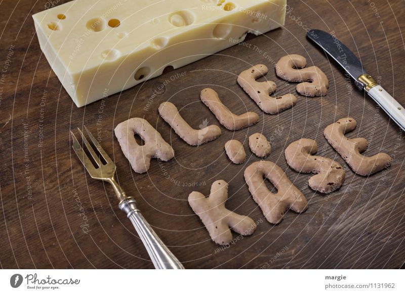 Die Buchstaben ALLES KÄSE auf einem rustikalen Holzbrett mit einem Stück Loch - Käse und Messer und Gabel Lebensmittel Ernährung Frühstück Abendessen Büffet