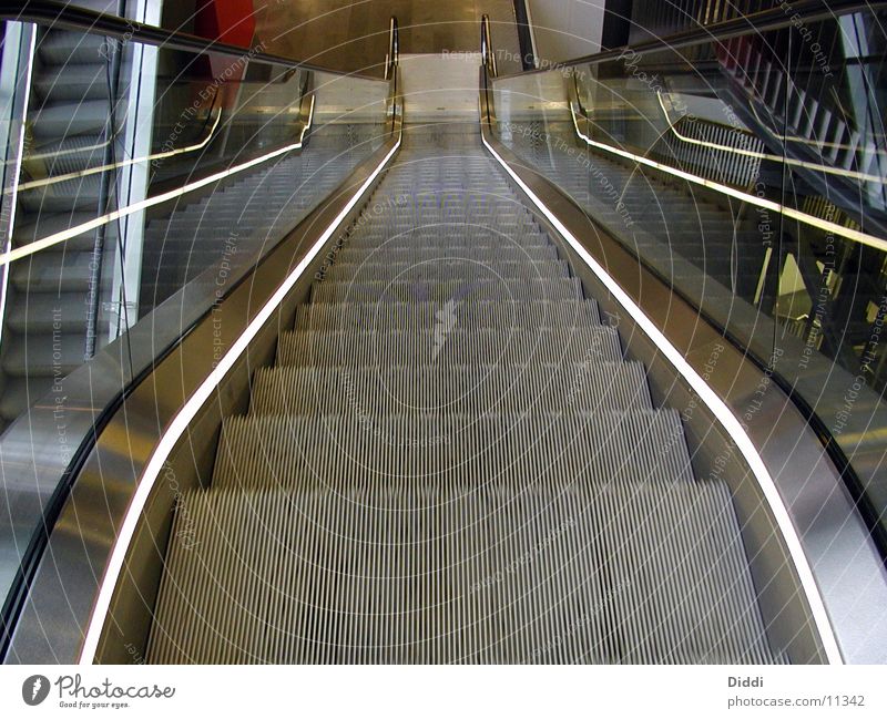 Rolltreppe oben Architektur Treppe Bewegung ab Leerfahrt leer Menschenleer Zentralperspektive Metall abwärts Treppengeländer Glas Beleuchtung