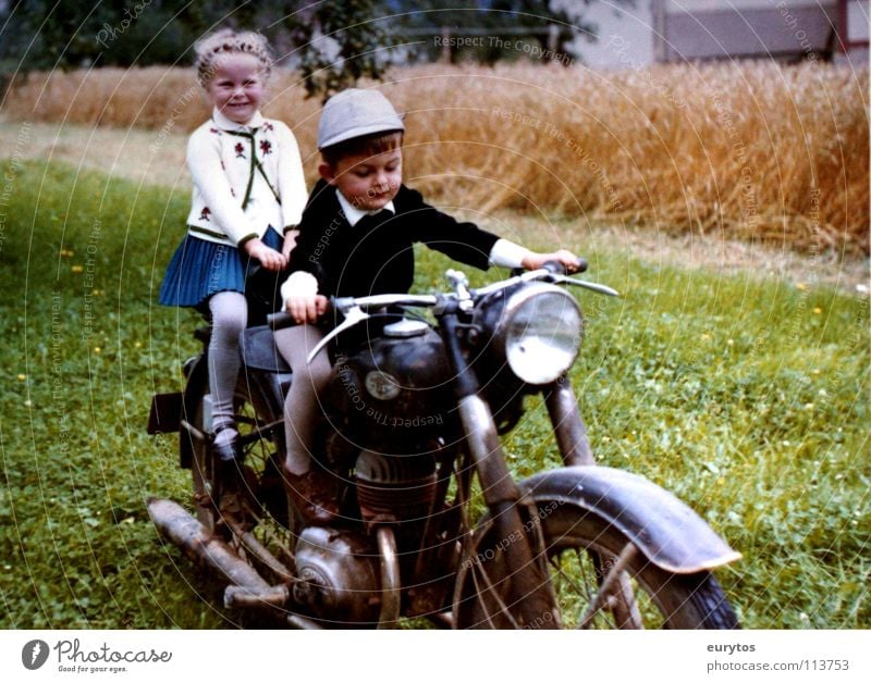 Wirtschaftswunderjahre... Farbfoto Außenaufnahme Freude Lampe Kind Mädchen Junge Wiese Feld Motorrad Kleinmotorrad Hut grün Frieden Weizenfeld