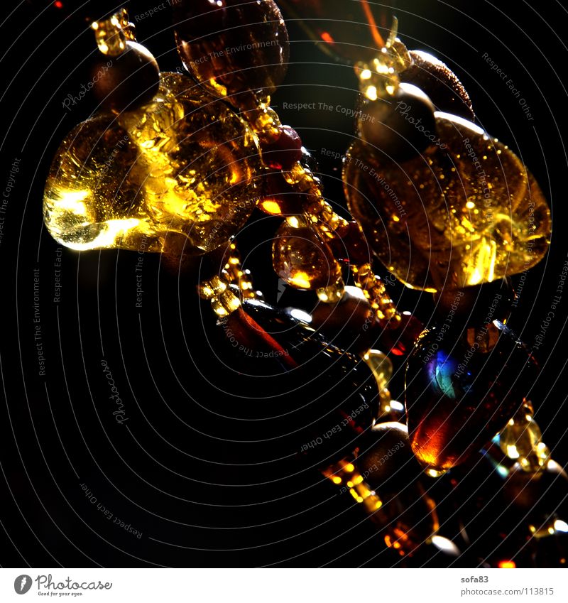 kette II Perle dunkel gelb diagonal Glasperle Gegenlicht Schmuck Kunst Kunsthandwerk Makroaufnahme Nahaufnahme Reichtum Kette