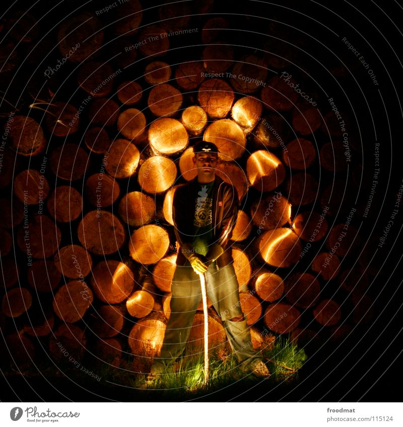 Holzfäller Schichtarbeit Taschenlampe Axt Brennholz rund Breitbeinig spreizen Licht Streifen Gras dunkel lässig unheimlich gruselig Langzeitbelichtung