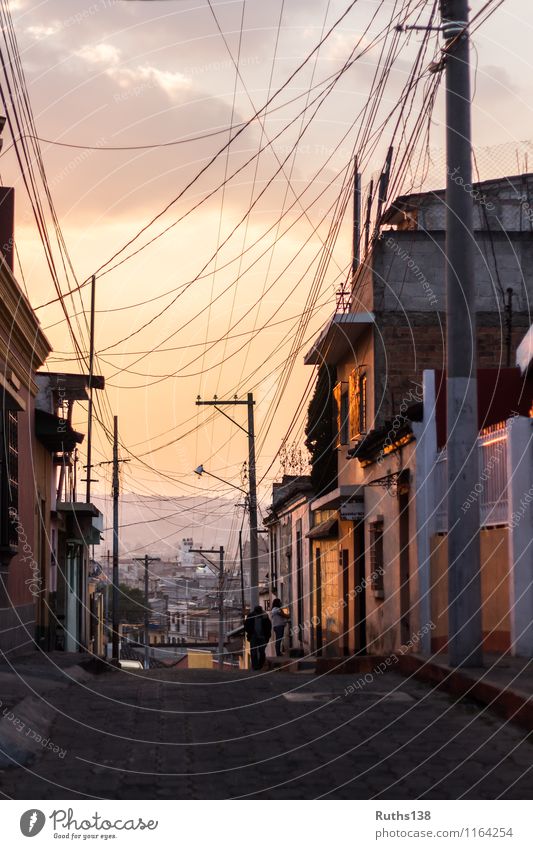 Sonnenuntergang in einer typischen Straße von Xela in Guatemala Stadt bevölkert Haus Mauer Wand Ferne gold orange Kabel Land Abenddämmerung Orangeton