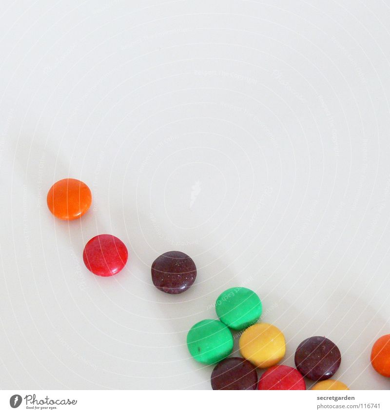 11 übriggeblieben Schokolade Schokolinsen rot gelb grün Überzug Zucker dünn Süßwaren weiß Tisch mehrfarbig Ernährung Pause klein Erinnerung