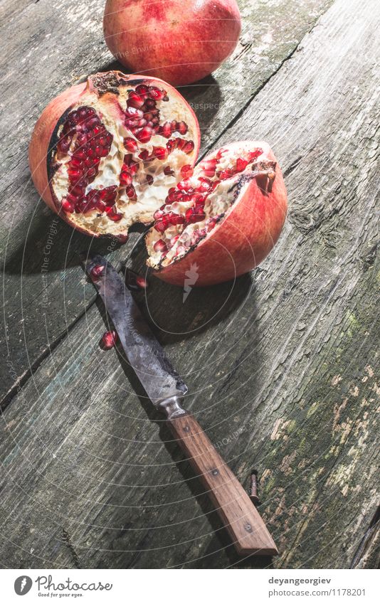 Granatapfel auf Vintage Holztisch Frucht Dessert Essen Vegetarische Ernährung Diät Saft Tisch alt dunkel frisch retro saftig rot Farbe hölzern Messer
