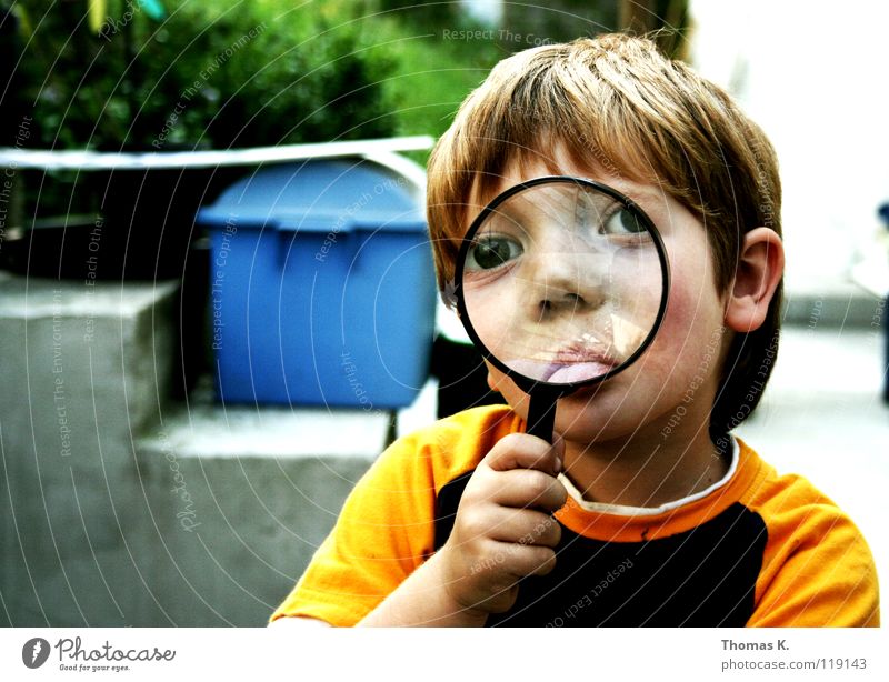 Through The Looking Glass II Kind Junge vergrößert Hand Brille suspekt Porträt untersuchen Nationale Sicherheit Spuren lesen Suche Suchprogramm finden