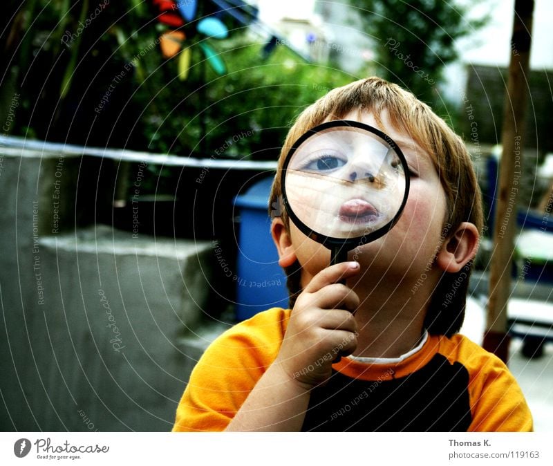 Through The Looking Glass III Kind Junge vergrößert Hand Brille suspekt Porträt untersuchen Nationale Sicherheit Spuren lesen Suche Suchprogramm finden