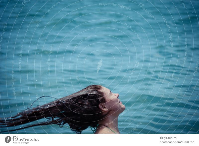 Ein Mädchen steht im Wasser und wirft ihre Nassen Haare mit Schwung nach hinten. Stil Freude Haare & Frisuren Leben Schwimmen & Baden Ausflug Meer Wassersport