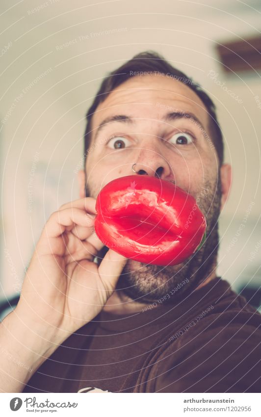 Junger Mann mit Paprika in Form von Lippen vor dem Mund Lebensmittel Gemüse Ernährung Freude Gesundheit Spielen Mensch maskulin Jugendliche Vater Erwachsene 1
