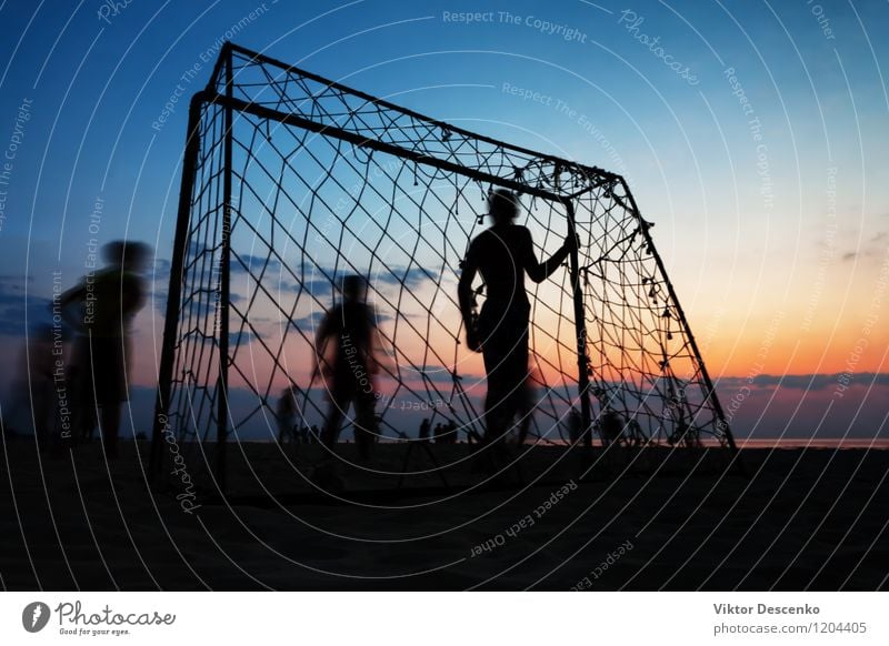 Jungen spielen Fußball am Tor am Sommerstrand bei Sonnenuntergang Lifestyle Freude Spielen Strand Meer Sport Mann Erwachsene 18-30 Jahre Jugendliche Landschaft