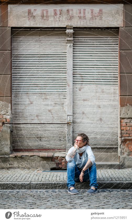 Junge Frau sitzt auf dem Gehweg vor einem verlassenen Haus Mensch Jugendliche Erwachsene Leben 1 Dorf Kleinstadt Stadt Altstadt Mauer Wand Fassade Fenster Tür