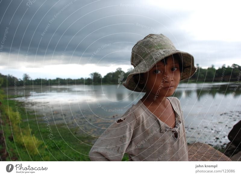 Ruhe vor dem Sturm ruhig Kind Mädchen Arme Wasser Regen Gewitter Fluss Wahrzeichen Denkmal Hut Armut Neugier Traurigkeit Sehnsucht Kambodscha Angkor Wat Monsun