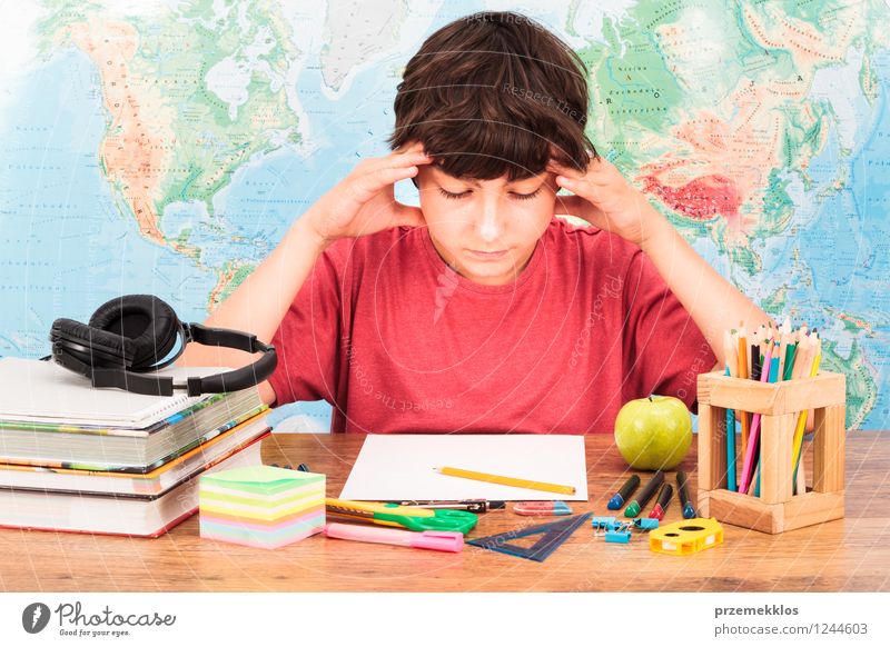 Junge denkt über seine Hausaufgaben nach Apfel Schreibtisch Bildung lernen Schulkind Student Arbeitsplatz Werkzeug Mensch 1 8-13 Jahre Kind Kindheit Buch Zettel