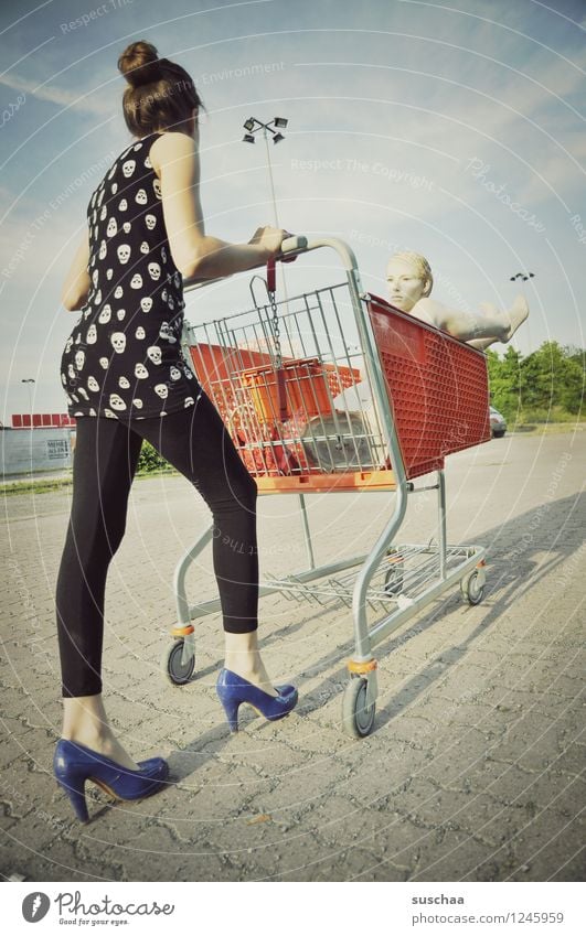 einkaufen gehen .... Kind Mädchen Fräulein Jugendliche Junge Frau schieben rennen Einkaufswagen Schaufensterpuppe Damenschuhe Kindheit skurril seltsam