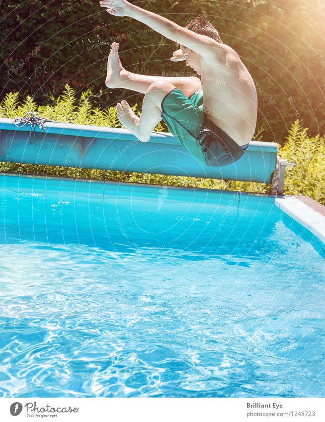 Junge springt ins Wasser hinein Lifestyle Sommer Sonne Schwimmbad Kind Sonnenlicht fliegen Sport springen ästhetisch sportlich authentisch nass positiv blau