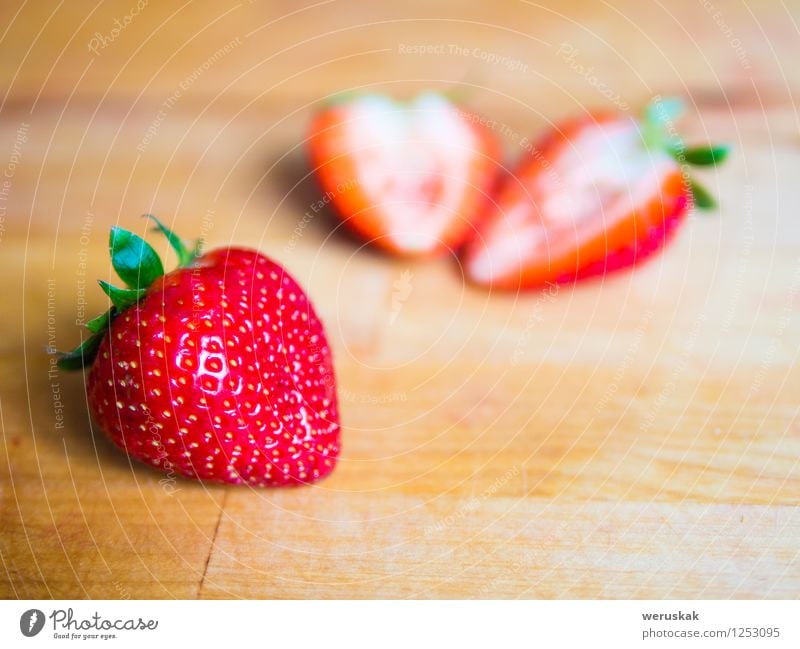 Erdbeere auf einem Holzbrett Frucht Ernährung Bioprodukte Vegetarische Ernährung Gesunde Ernährung Sommer frisch Gesundheit saftig süß grün rot Hintergrund