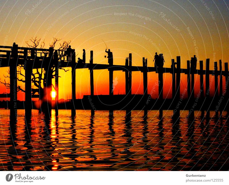 Birmanische Brücke Myanmar Mandalay Teak Holz Holzbrücke Asien Abenddämmerung See Gegenlicht Licht rot Baum u-bein Pfosten Wasser Schatten Silhouette Sonne