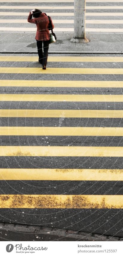 Schmalspur Fußgängerübergang Zebrastreifen gelb Asphalt Verkehr Stadt gehen Überqueren betoniert Teer Streifen schmal Frau Tasche Jacke Sicherheit Schutzweg