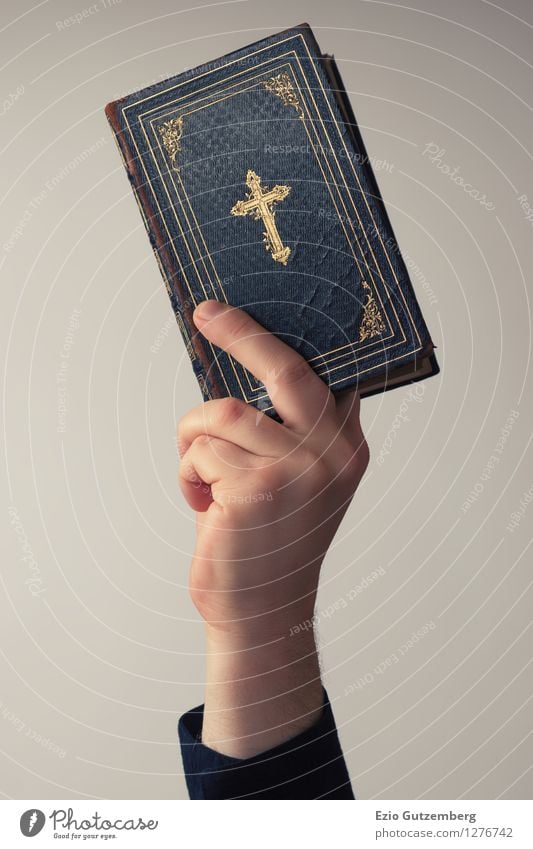 Eine Hand die eine Bibel in die Höhe hält schön Beruf Mensch maskulin Finger Buch lesen Hemd Papier festhalten ästhetisch hell retro seriös Macht gewissenhaft