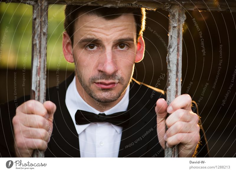 trauriger Mann im Anzug hinter Gittern gefangen Gitterstäbe eingesperrt verschlossen Mensch verbot