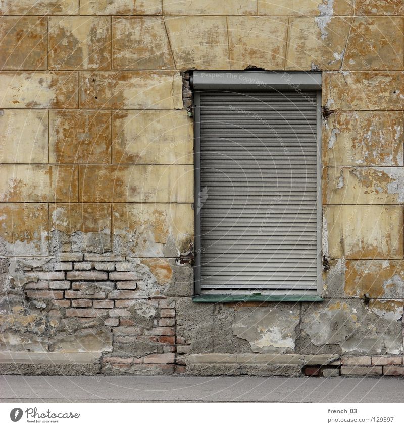 wohnst du noch? Haus Wand Mauer Fenster Rollladen gelb kaputt verrotten Backstein veraltet Gebäude beige Putz zerbröckelt geschlossen Unbewohnt Einsamkeit leer