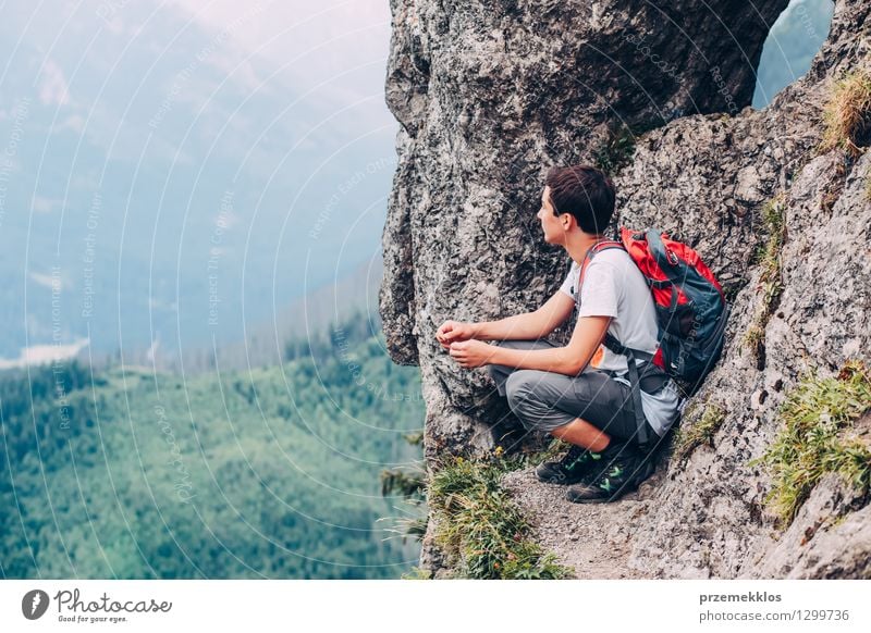 Junge sitzt auf einem Felsen in den Bergen und blickt auf ein Tal Ferien & Urlaub & Reisen Abenteuer Sommer Sommerurlaub Berge u. Gebirge wandern Kind