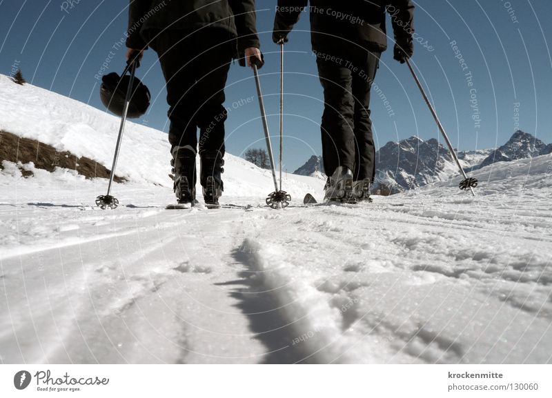 black in white Winter Skifahren Skifahrer weiß Skier 2 Wintersport Winterurlaub kalt Skistöcke Helm Bergkette Froschperspektive schwarz Schneeanzug anstrengen