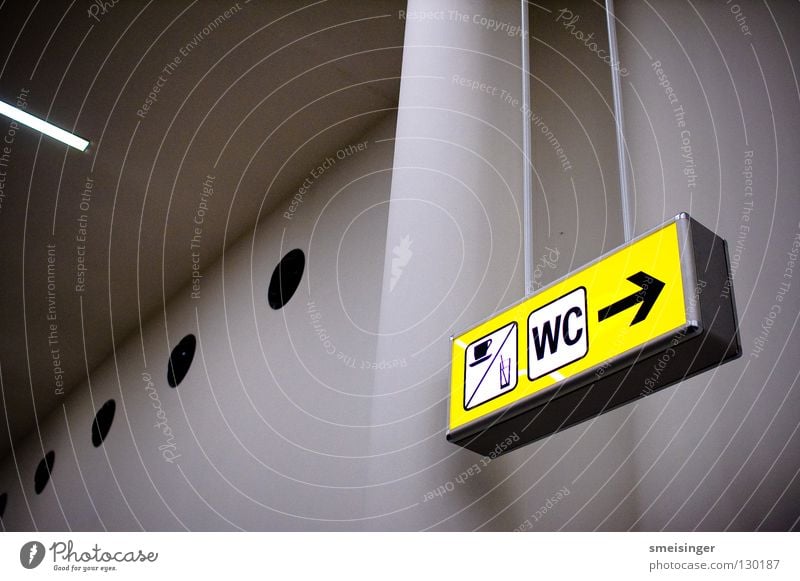 Müßiggang Licht gelb Hinweisschild weiß kalt Information Flughafen Buchstaben Schriftzeichen Uwe Toilette Raum hoch Schilder & Markierungen Pfeil Wegweise Säule