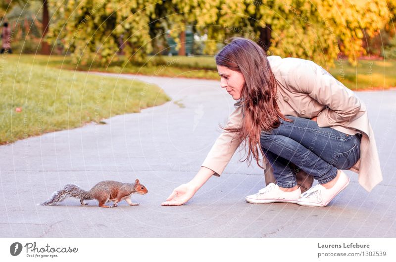 Mädchen und Eichhörnchen feminin Junge Frau Jugendliche 1 Mensch 18-30 Jahre Erwachsene Garten Wildtier Tier Tierjunges Essen Fressen füttern knien Lächeln