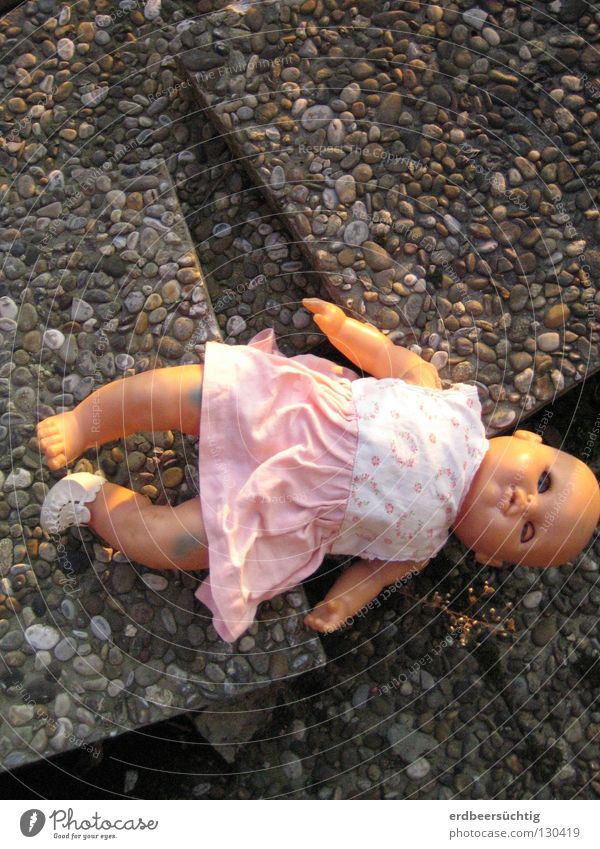 Lost childhood Kindheit Kleid Spielzeug Puppe alt Traurigkeit kaputt Trauer unschuldig Vergänglichkeit Zeit Babypuppe Steinplatten verloren vergangen früher